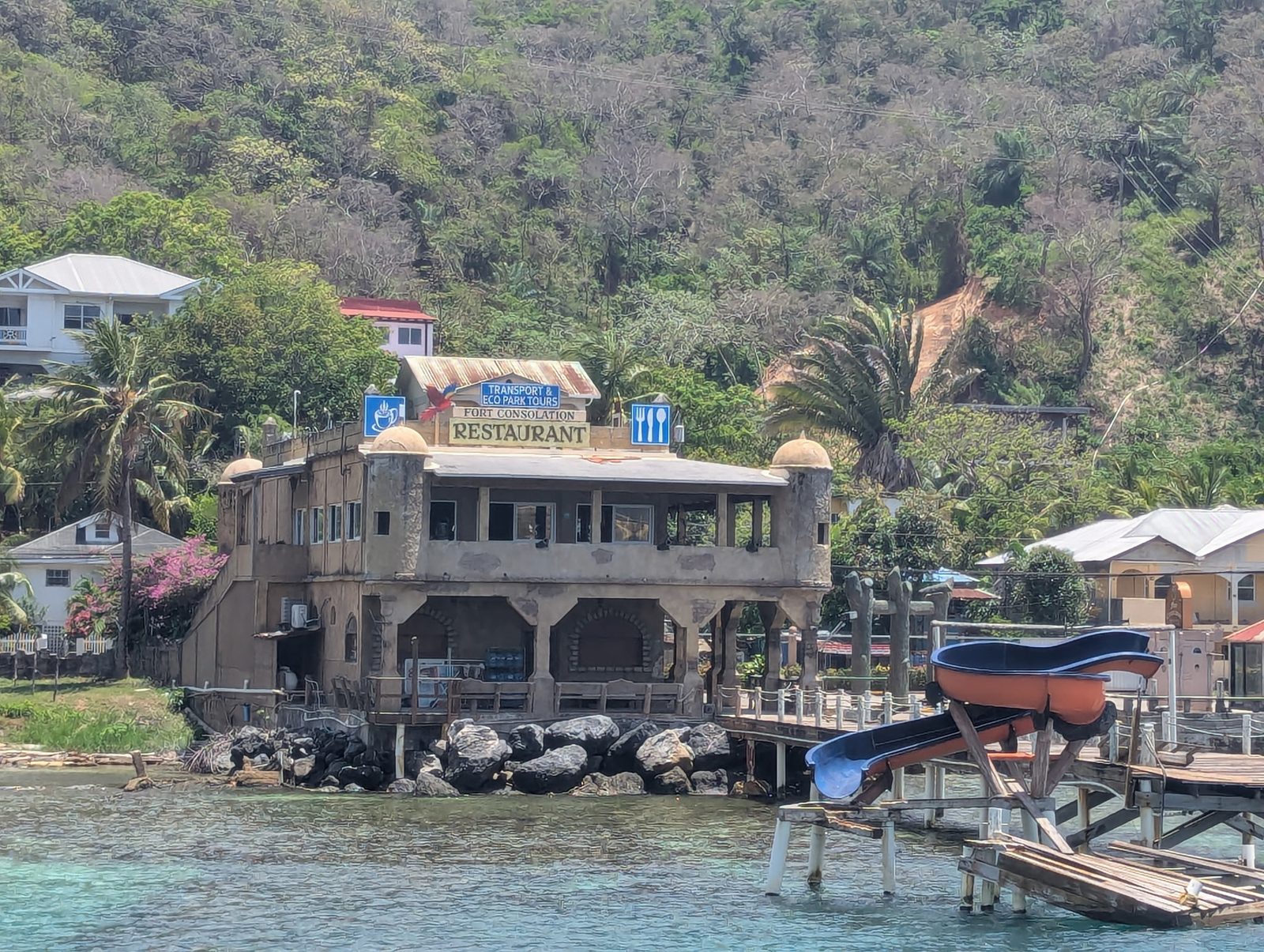 A waterfront dining building built out over calm water, with a dock alongside
